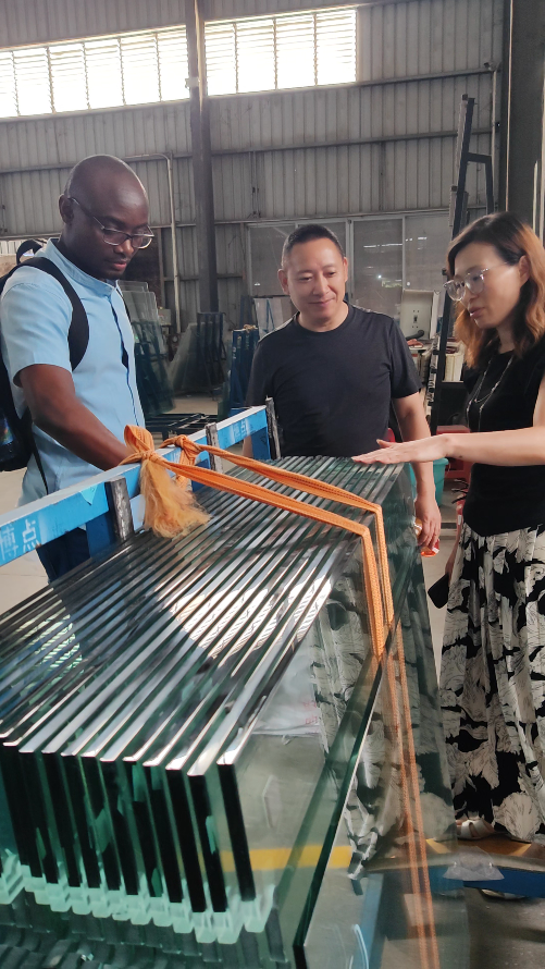 Team and overseas client at glass production line